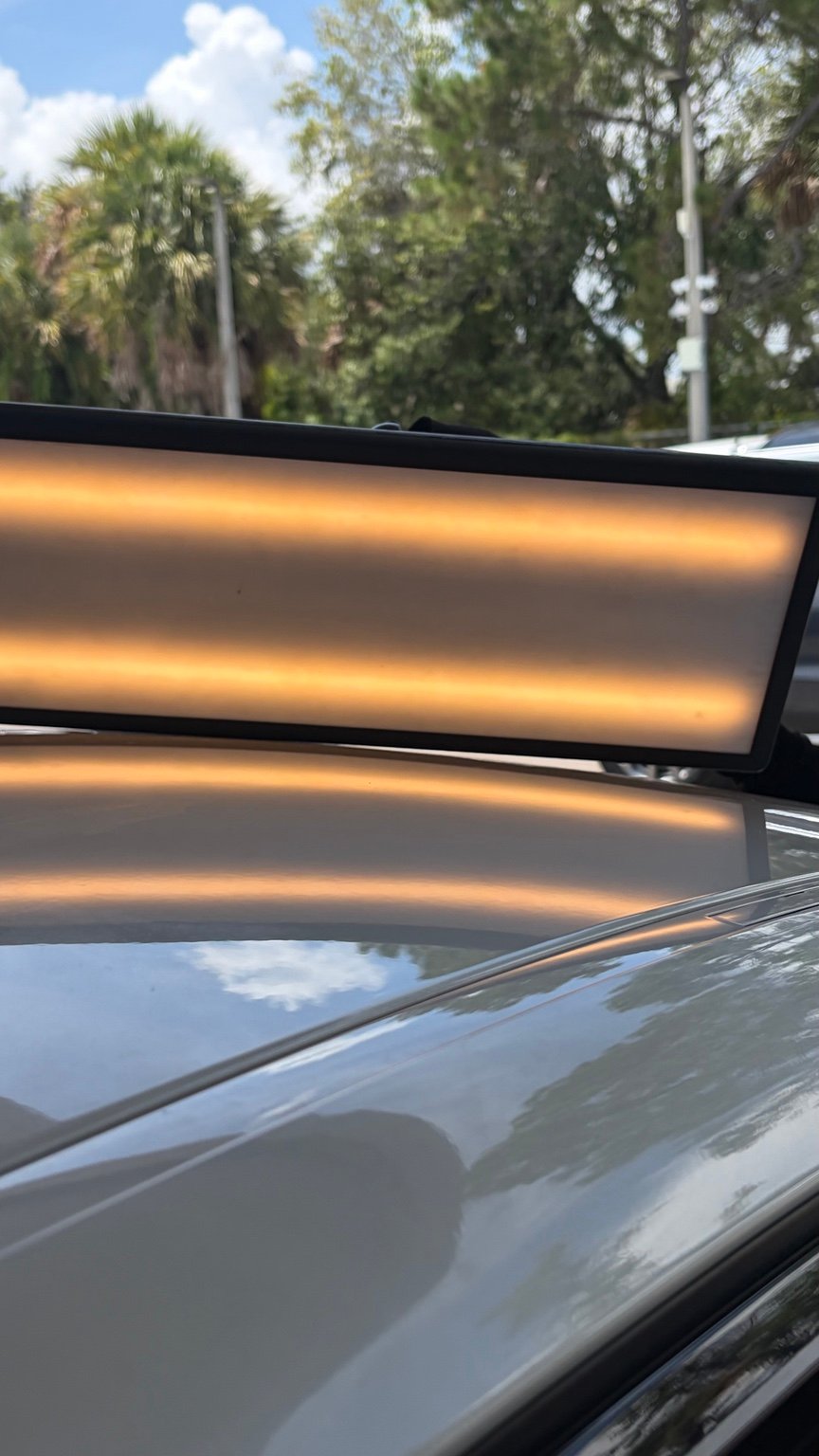 Roof panel after paintless dent repair, photographed with a repair light